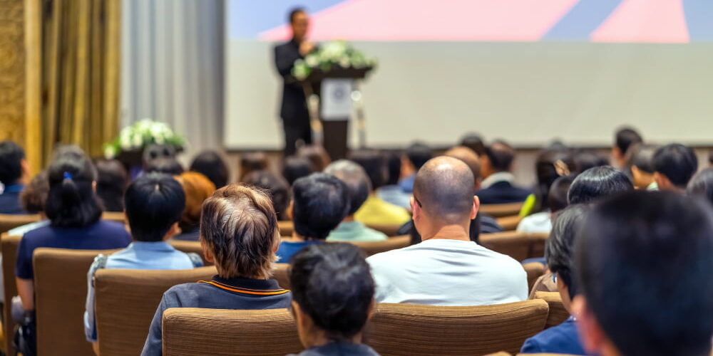 back-side-audience-listening-speaker-with-podium-stage-conference-hall