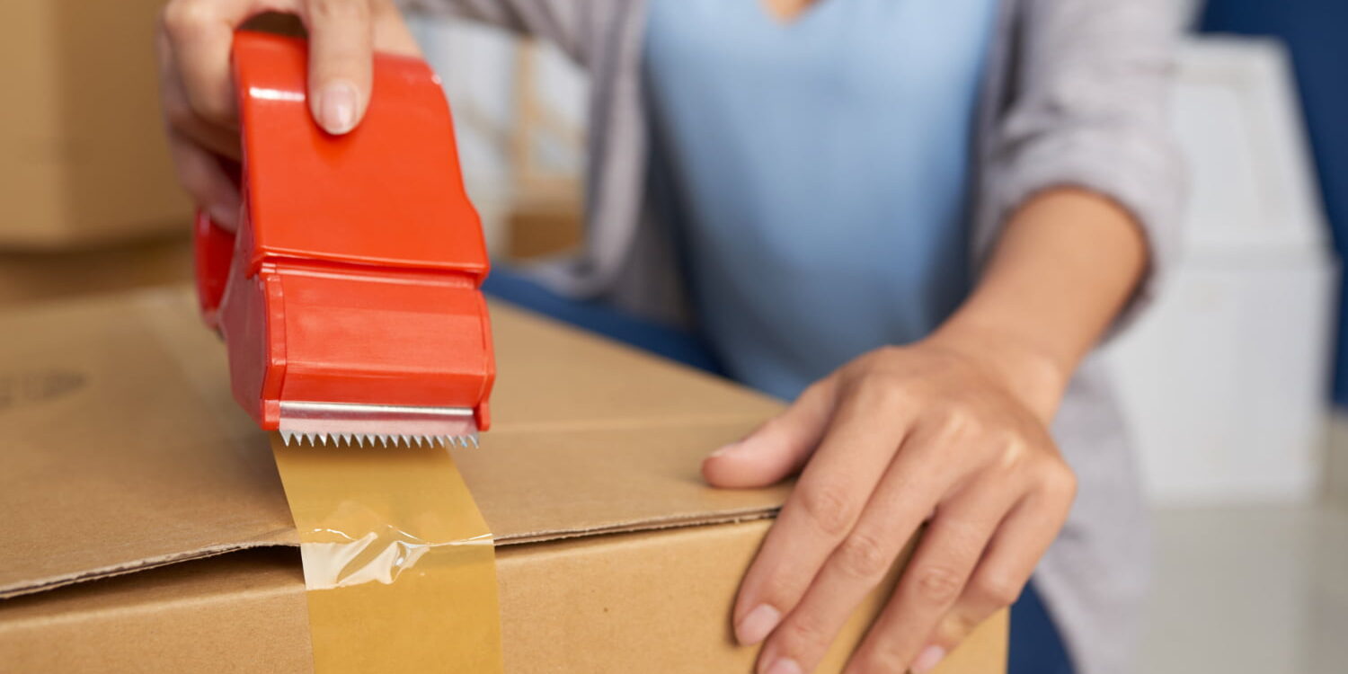 woman-packing-box-with-tape