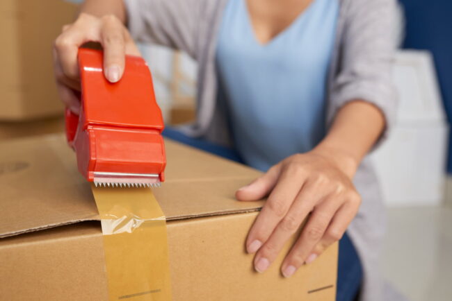 woman-packing-box-with-tape