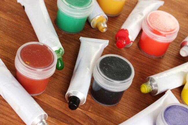 tubes-with-colorful-watercolors-jars-with-gouache-wooden-table-closeup