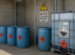 Secure hazardous chemical storage area with blue drums and safety-labeled containers, illustrating safe chemical storage compliance practices in industrial settings.